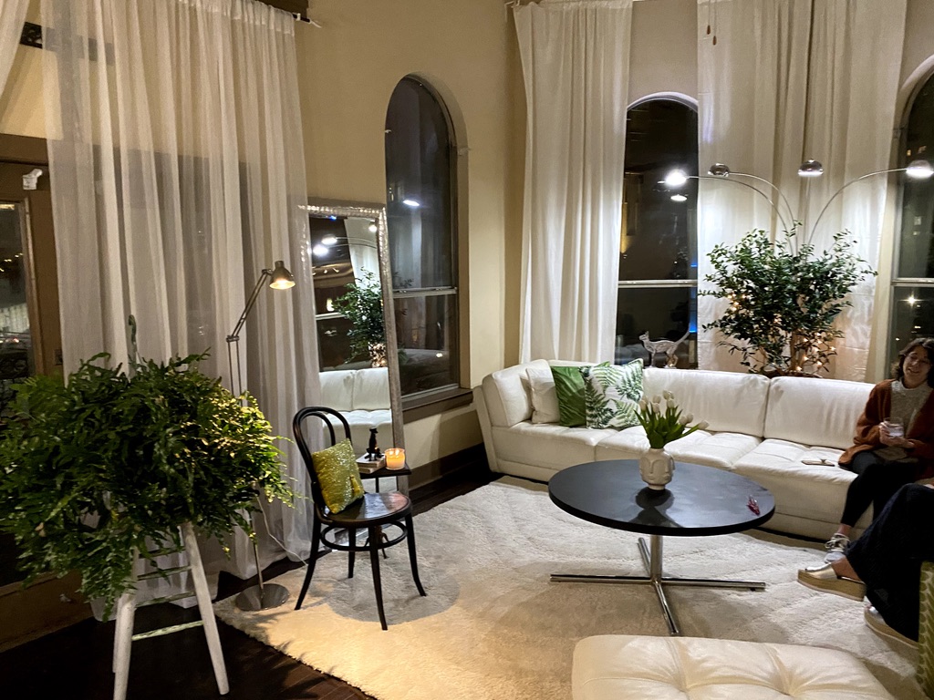 Living area with deep forest tones, botanical accents, and layered warm lighting